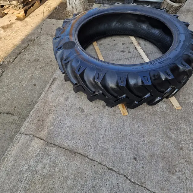 Anvelopă agricolă așezată pe un palet, în curtea atelierului