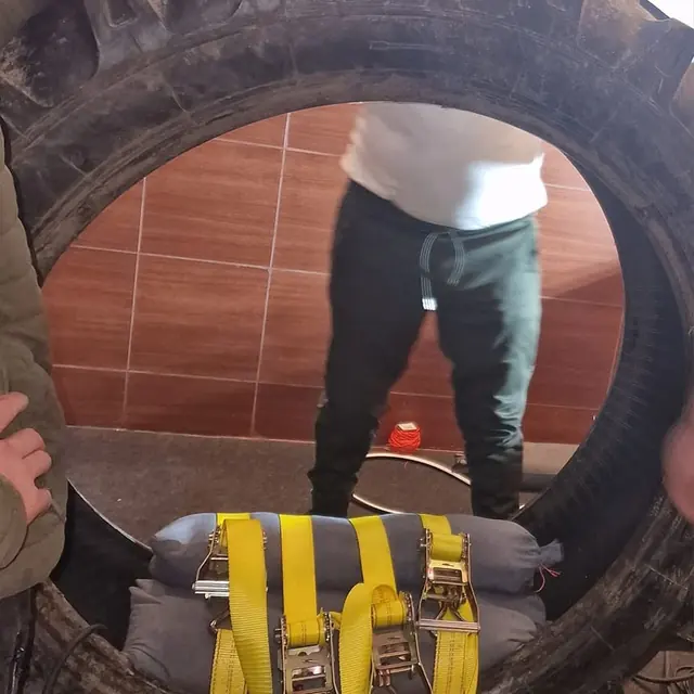 Anvelopă de tractor în atelier, cu presa de vulcanizare prinsă în chingi