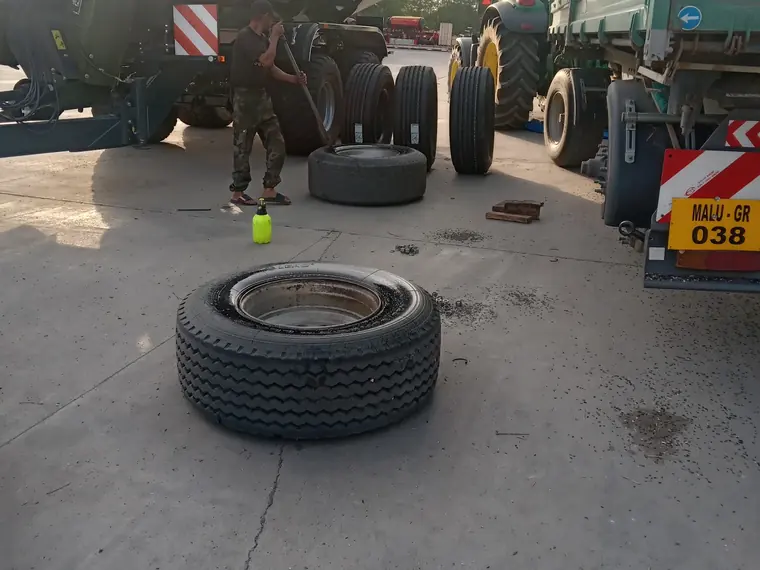 Anvelopă de camion pe asfalt, între remorci, în timpul unei intervenții